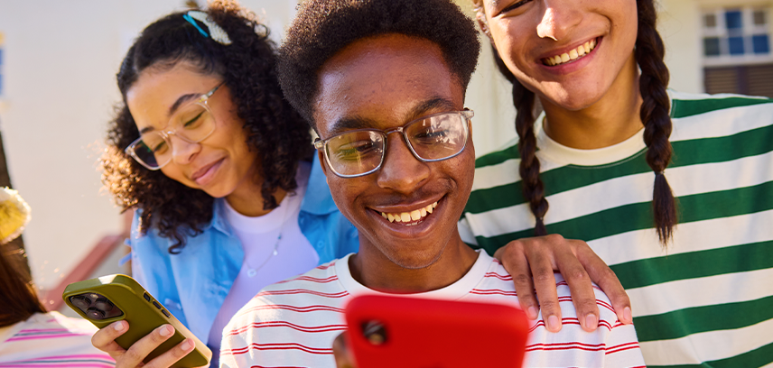 Happy teens looking at phones together 