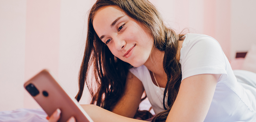 Teenage girl watching YouTube on her phone