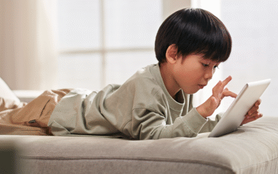child scrolling videos on ipad, lying on bed with tablet
