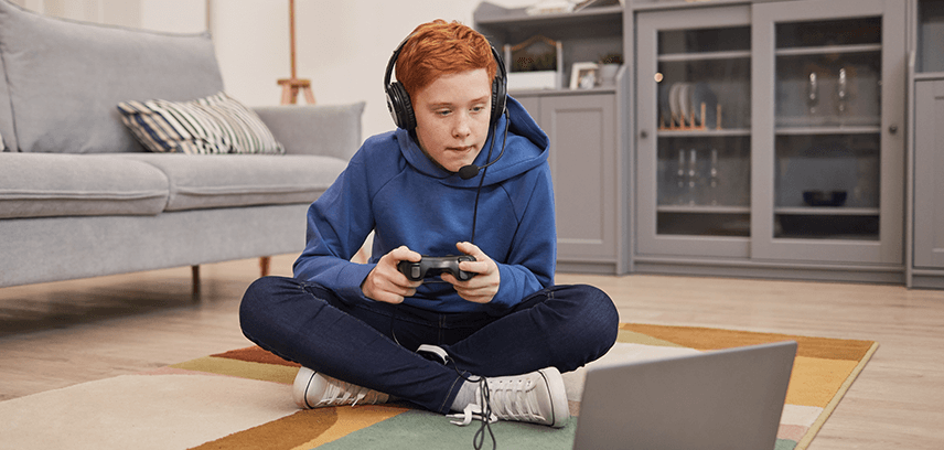 Teenage boy gaming on laptop