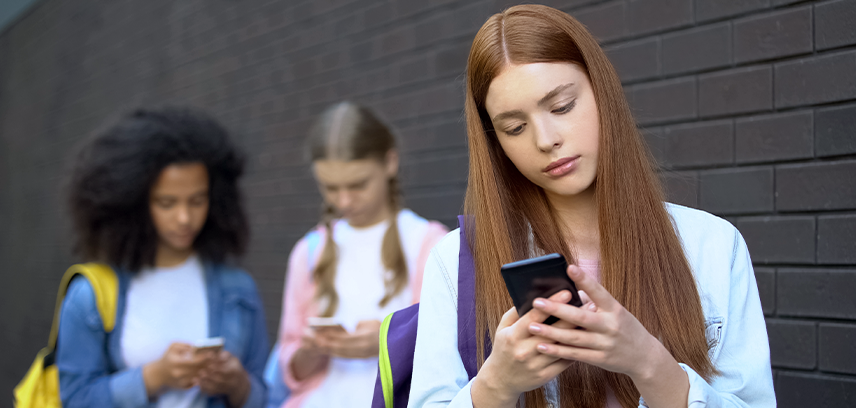 Three teenage girls using smartphones 