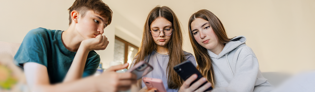 Three teenagers using smartphones