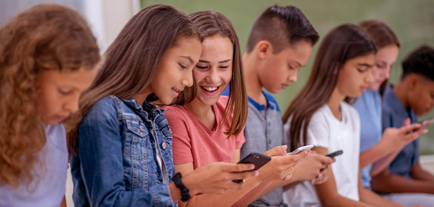 children messaging together on phones having fun and laughing together