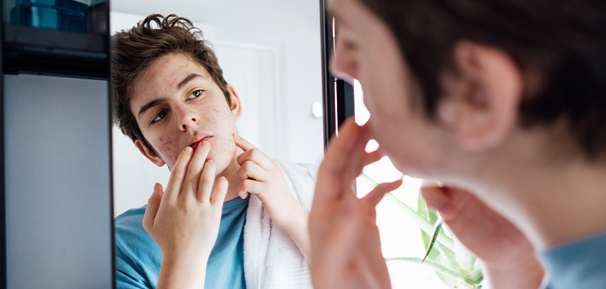 Teen boy looking in mirror