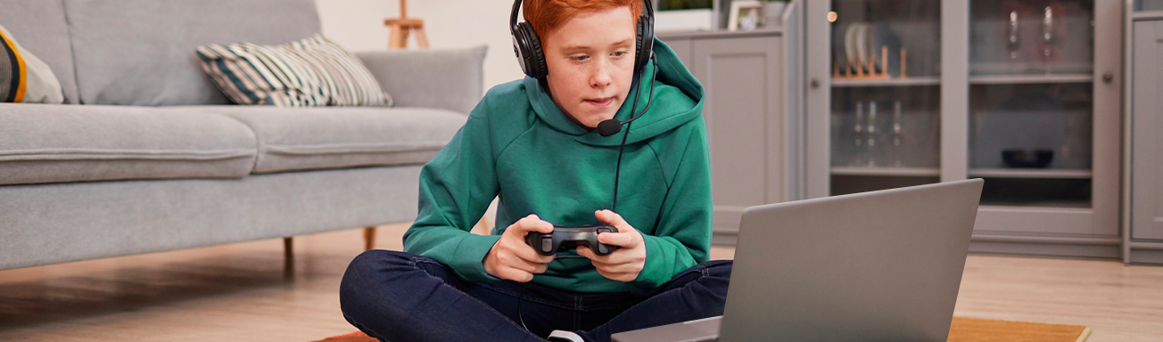 Teenage boy playing games on laptop