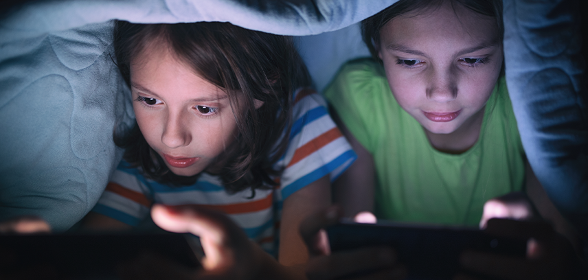 Kids playing games under bed covers