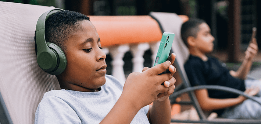 Boy using smartphone with headphones on 