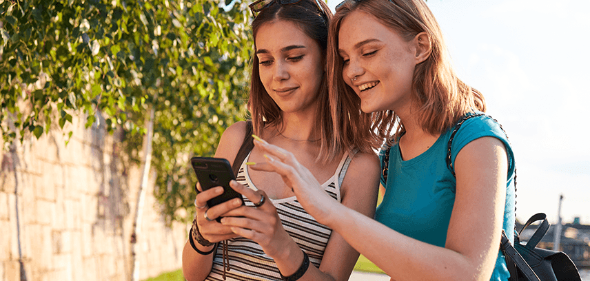Teenage girls using smart phones