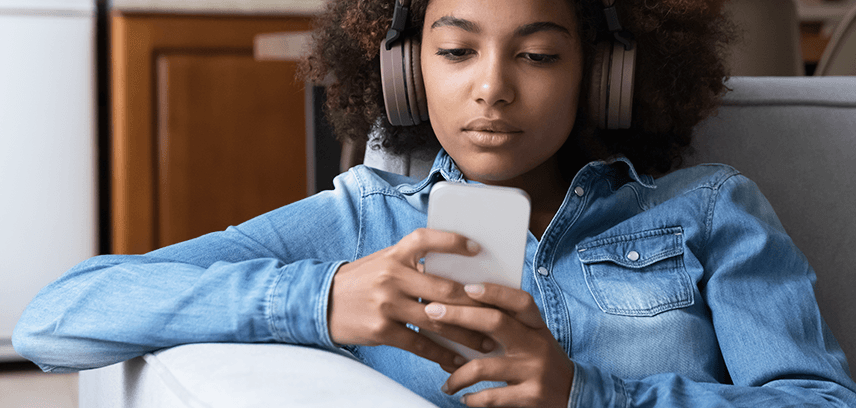 Teen boy using smartphone with headphones