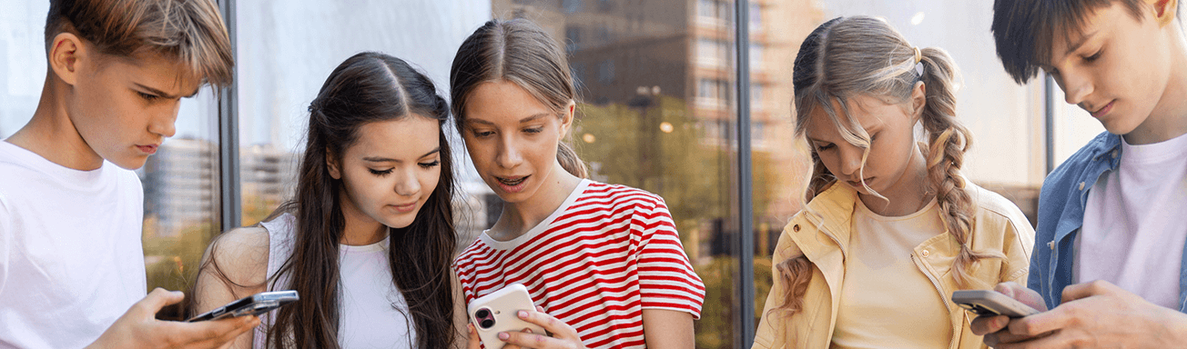 Teens gathering around their smartphones